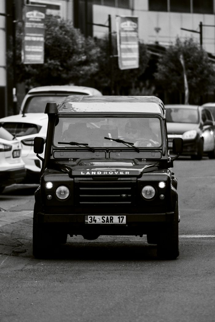 Black and white photo of a Land Rover driving through city streets of Istanbul, Türkiye.